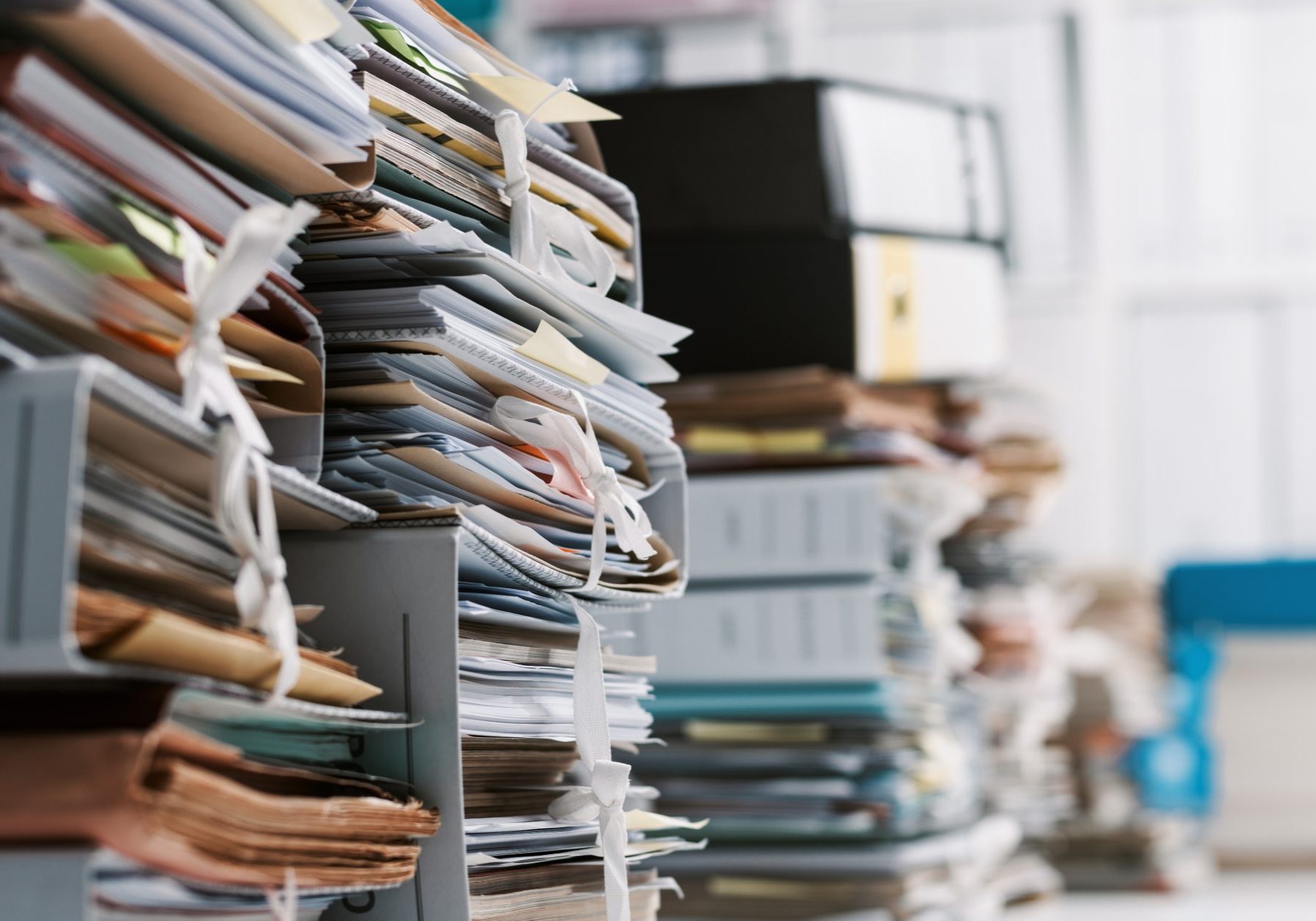 Stacks of paperwork and files in the office: work overload, files management and administration concept